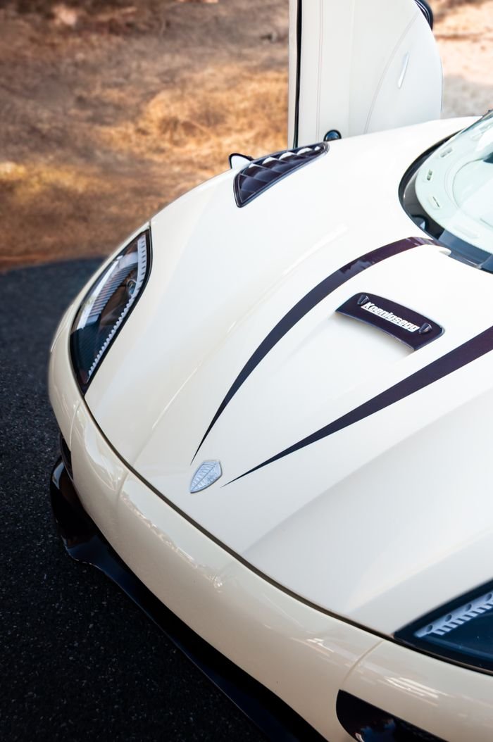 Services Close-up shot of a cream-colored luxury convertible hypercar with stylish carbon fiber details.